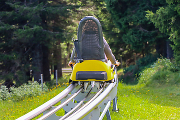 Image showing Young girl enjoying a summer fun roller alpine coaster ride