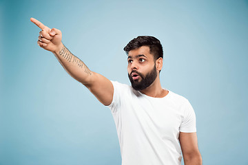 Image showing Half-length close up portrait of young man on blue background.