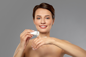 Image showing woman applying moisturizing cream to her hand
