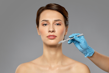 Image showing beautiful young woman and hand with scalpel