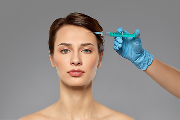 Image showing beautiful young woman and hand with syringe