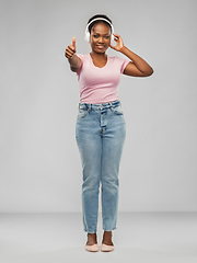 Image showing african woman in headphones showing thumbs up