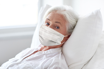 Image showing old woman patient in mask lying in bed at hospital