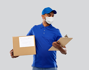 Image showing delivery man in mask with parcel box and clipboard