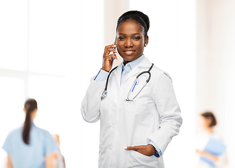 Image showing african female doctor calling on smartphone