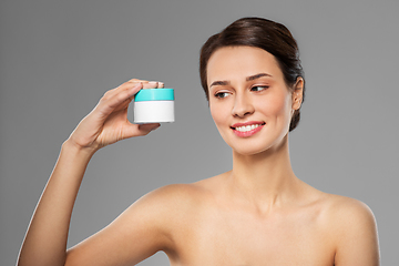 Image showing happy young woman holding jar of cream