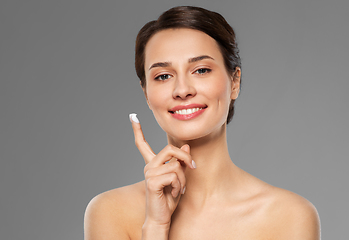 Image showing young woman with moisturizing cream on finger