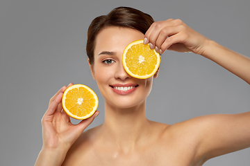 Image showing beautiful woman making eye mask of orange slices