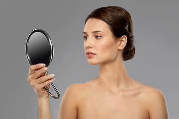 Image showing beautiful young woman looking to mirror