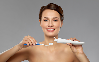 Image showing smiling woman with toothbrush cleaning teeth