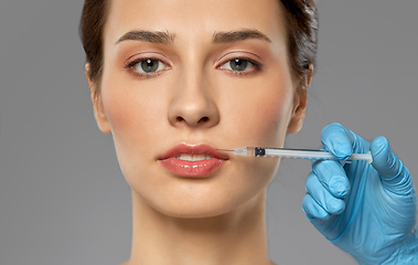 Image showing beautiful young woman and hand with syringe