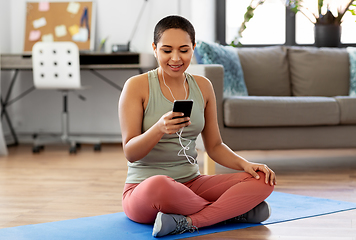 Image showing woman with earphones and smartphone doing sports