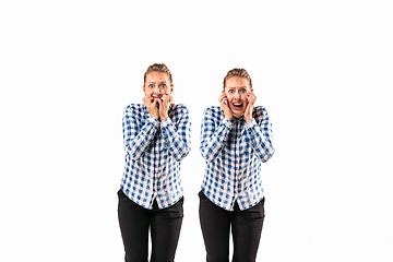 Image showing Young handsome woman arguing with herself on white studio background.