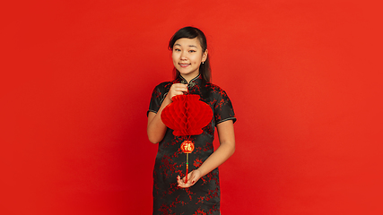 Image showing Happy Chinese new year. Asian young girls\'s portrait isolated on red background