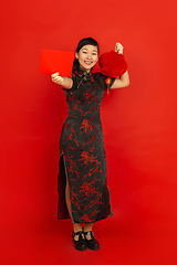 Image showing Happy Chinese new year. Asian young girls\'s portrait isolated on red background