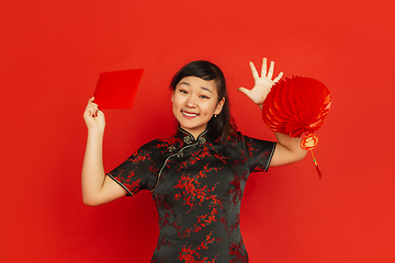 Image showing Happy Chinese new year. Asian young girls\'s portrait isolated on red background