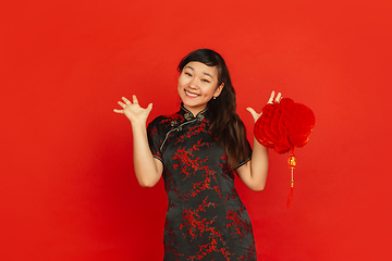 Image showing Happy Chinese new year. Asian young girls\'s portrait isolated on red background