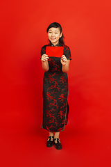 Image showing Happy Chinese new year. Asian young girls\'s portrait isolated on red background