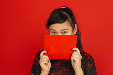 Image showing Happy Chinese new year. Asian young girls\'s portrait isolated on red background
