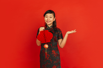 Image showing Happy Chinese new year. Asian young girls\'s portrait isolated on red background