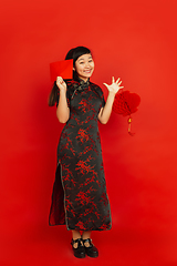 Image showing Happy Chinese new year. Asian young girls\'s portrait isolated on red background