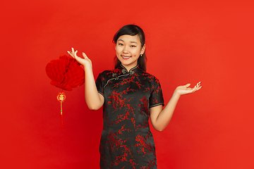 Image showing Happy Chinese new year. Asian young girls\'s portrait isolated on red background