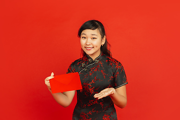 Image showing Happy Chinese new year. Asian young girls\'s portrait isolated on red background