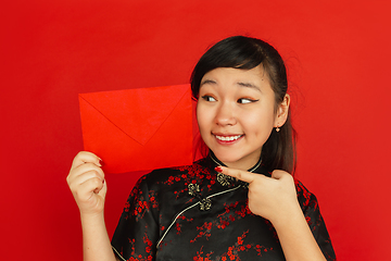 Image showing Happy Chinese new year. Asian young girls\'s portrait isolated on red background