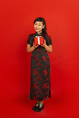 Image showing Happy Chinese new year. Asian young girls\'s portrait isolated on red background