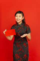 Image showing Happy Chinese new year. Asian young girls\'s portrait isolated on red background