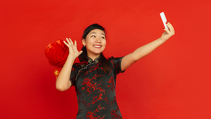 Image showing Happy Chinese new year. Asian young girls\'s portrait isolated on red background