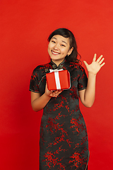 Image showing Happy Chinese new year. Asian young girls\'s portrait isolated on red background