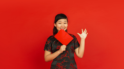 Image showing Happy Chinese new year. Asian young girls\'s portrait isolated on red background