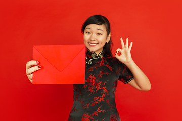 Image showing Happy Chinese new year. Asian young girls\'s portrait isolated on red background