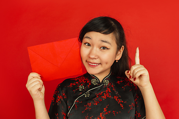 Image showing Happy Chinese new year. Asian young girls\'s portrait isolated on red background