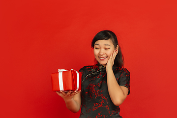 Image showing Happy Chinese new year. Asian young girls\'s portrait isolated on red background