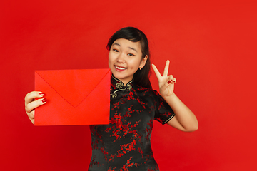 Image showing Happy Chinese new year. Asian young girls\'s portrait isolated on red background