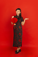 Image showing Happy Chinese new year. Asian young girls\'s portrait isolated on red background