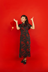 Image showing Happy Chinese new year. Asian young girls\'s portrait isolated on red background