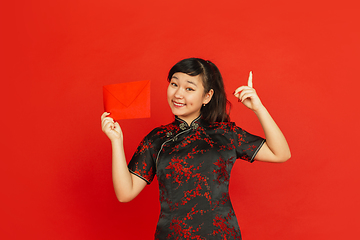 Image showing Happy Chinese new year. Asian young girls\'s portrait isolated on red background