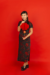 Image showing Happy Chinese new year. Asian young girls\'s portrait isolated on red background