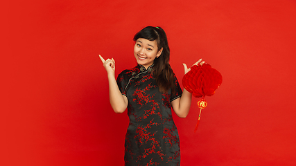 Image showing Happy Chinese new year. Asian young girls\'s portrait isolated on red background