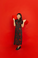 Image showing Happy Chinese new year. Asian young girls\'s portrait isolated on red background