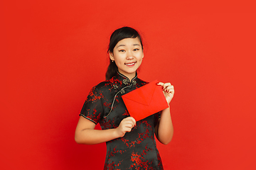 Image showing Happy Chinese new year. Asian young girls\'s portrait isolated on red background