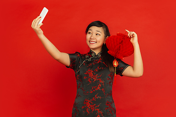 Image showing Happy Chinese new year. Asian young girls\'s portrait isolated on red background