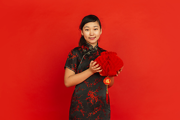 Image showing Happy Chinese new year. Asian young girls\'s portrait isolated on red background