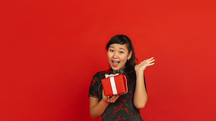 Image showing Happy Chinese new year. Asian young girls\'s portrait isolated on red background