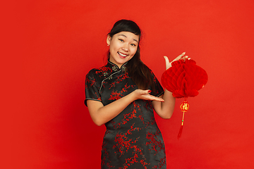 Image showing Happy Chinese new year. Asian young girls\'s portrait isolated on red background