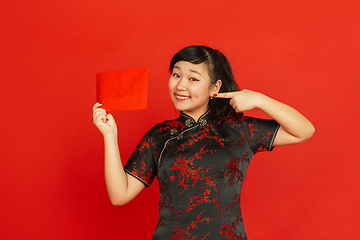 Image showing Happy Chinese new year. Asian young girls\'s portrait isolated on red background