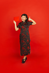 Image showing Happy Chinese new year. Asian young girls\'s portrait isolated on red background